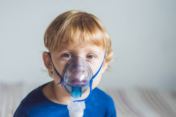 istock Boy making inhalation with a nebulizer at home 827967270