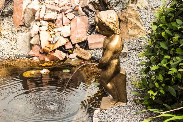A bronze statue of a boy in the garden