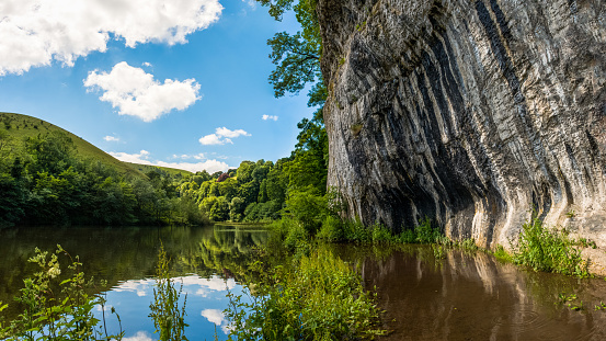 A Flooded lake and cliff, near Cressbrook in the Peak District, UK.