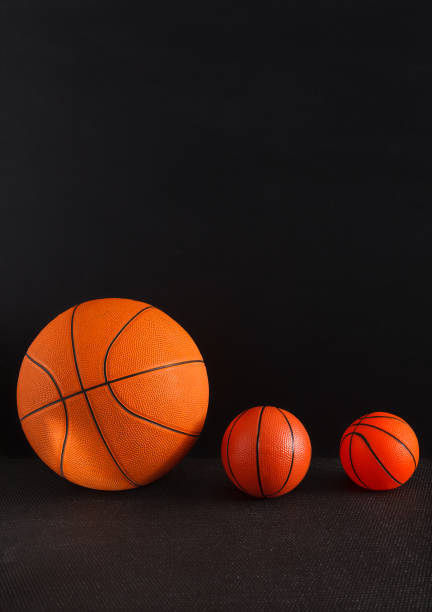 istock Big and small basketball balls on black background 827968470