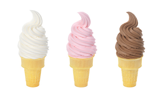 Three flavors of soft serve ice cream or frozen yogurt, swirled onto wafer cones and isolated on a white background. From left to right are: vanilla, strawberry/cherry, and chocolate.
