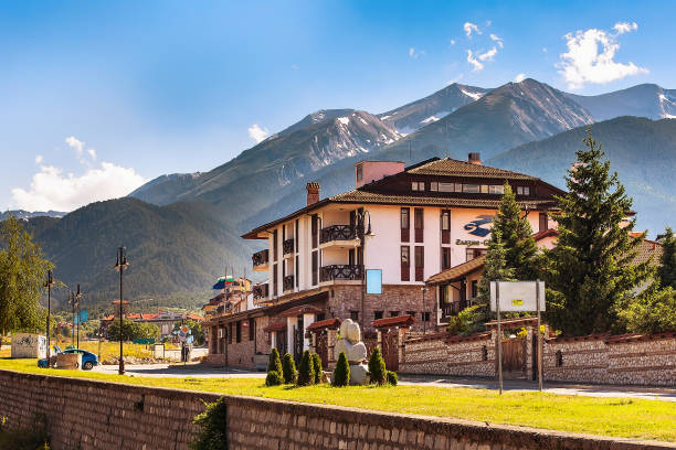 bansko, bulgaria vista in estate con hotel, fiume e montagne - bansko foto e immagini stock