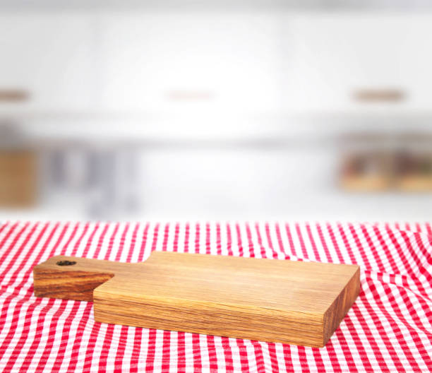 istock Wooden empty cutting board on picnic cloth background. 827978574