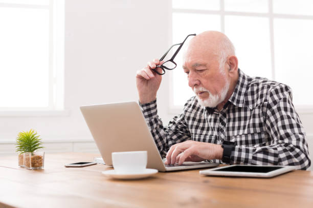 istock Worried senior man using laptop at home 827979494