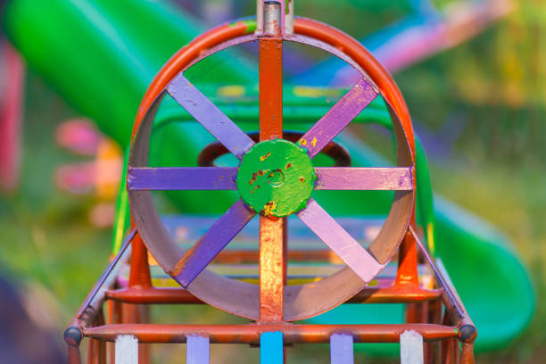 Colorful iron train swinging at the playground under the sunlight in summer.