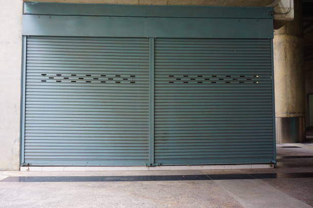 istock Aluminium steel roller shutter door and tile floor in warehouse building 827982762