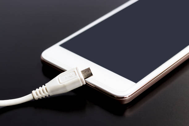 Charger cable for mobile phone on black background.