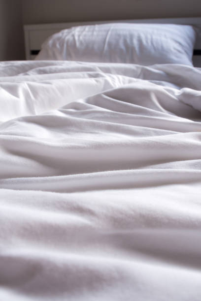 istock White blanket crumpled on the bed 827987244