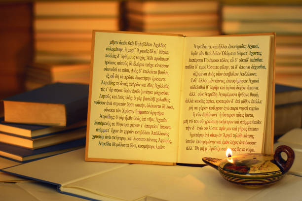 istock Open book illuminated by an oil lamp. Iliad opening lines. 827988090
