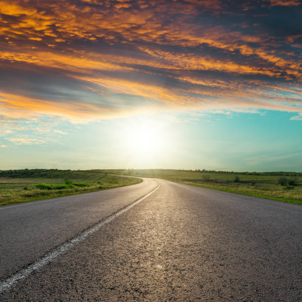 istock asphalt road to horizon in red clouds in sunset 827995234