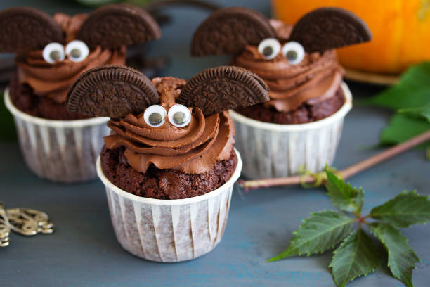 Chocolate muffins, on Halloween. Chocolate muffins, with a chocolate cream in the form of bat on Halloween.Chocolate muffins, with a chocolate cream in the form of bat on Halloween. halloween cupcake stock pictures, royalty-free photos & images