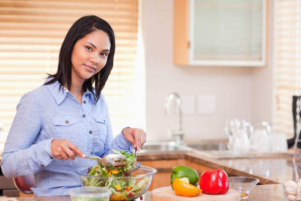 istock Woman stirring her salad in the kitchen 827995646
