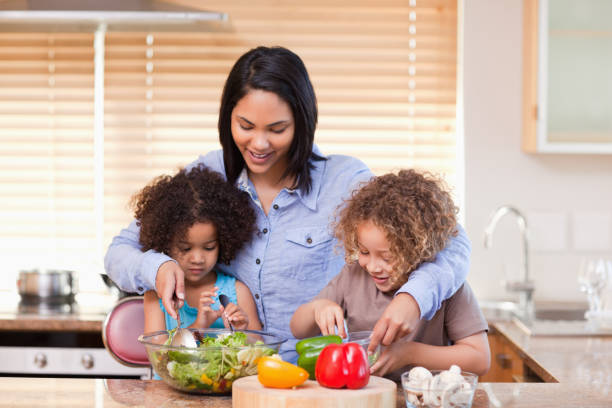 istock Mother and daughters preparing salad in the kitchen together 827996202