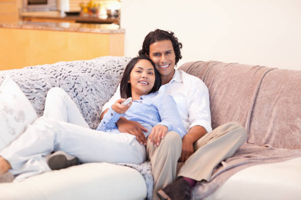 istock Couple enjoys watching television together 827998810