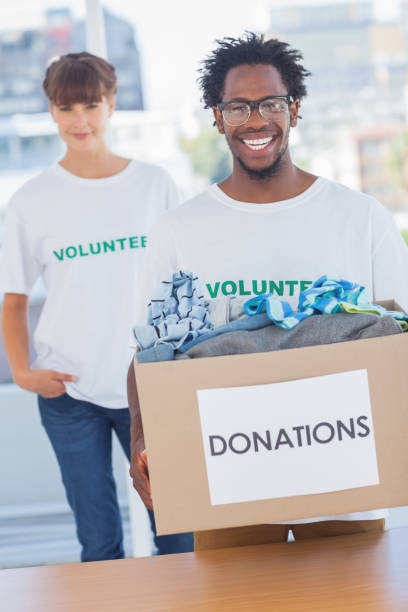 istock Handsome man holding donation box next to a colleague 827999584