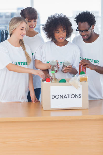 istock Volunteers putting food in donation box 828000224