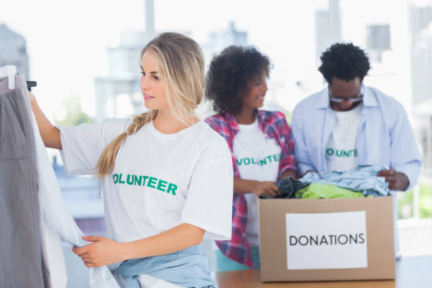 istock Volunteers putting clothes in clothes rail 828000868