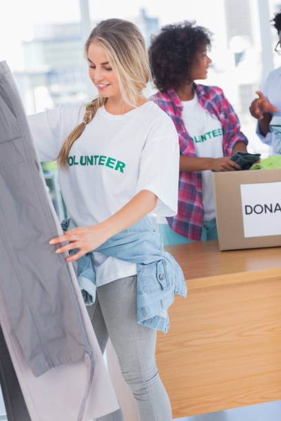 istock Smiling volunteers putting clothes in clothes rail 828000948