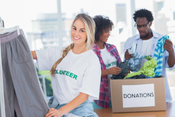 istock Cheerful volunteers putting clothes in clothes rail 828001014