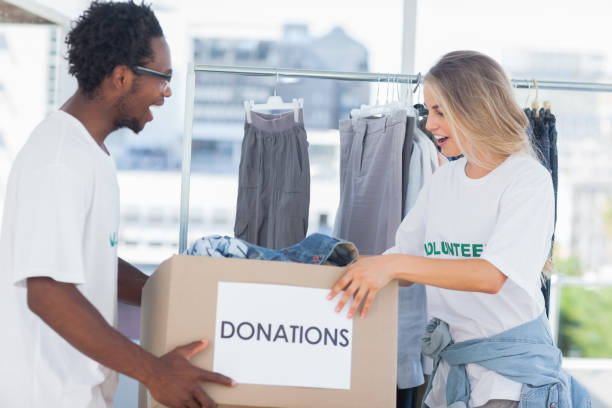 istock Cheerful volunteers looking at a donation box 828001240