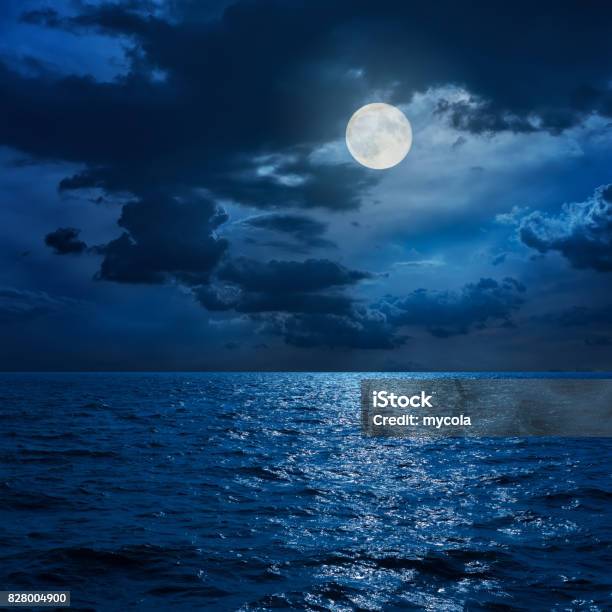 Full Moon In Clouds Over Sea In Night Stock Photo - Download Image Now - Night, Moon, Moon Surface
