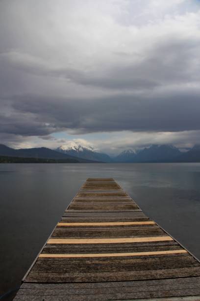 wooden pier overlooking mountains - mcdonald lake imagens e fotografias de stock