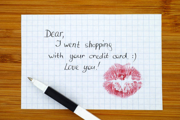 uwaga - szanowni państwo, poszedłem na zakupy z twoją kartą kredytową. kocham cię! z pocałunkiem i długopisem. - stealing a kiss zdjęcia i obrazy z banku zdjęć