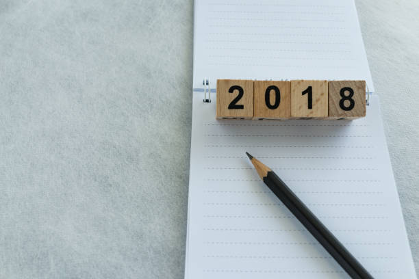istock next year goals or target concept with wooden blocks number 2018 and pencil on white note paper with copy space 828034026