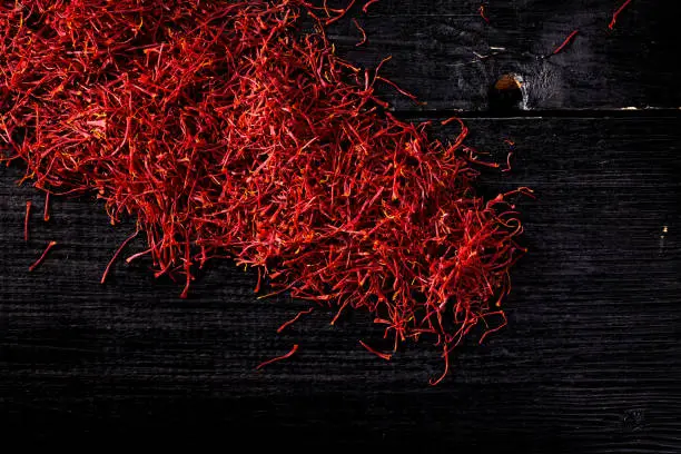 saffron crocus threads on black wooden board, view from above, backgrounds