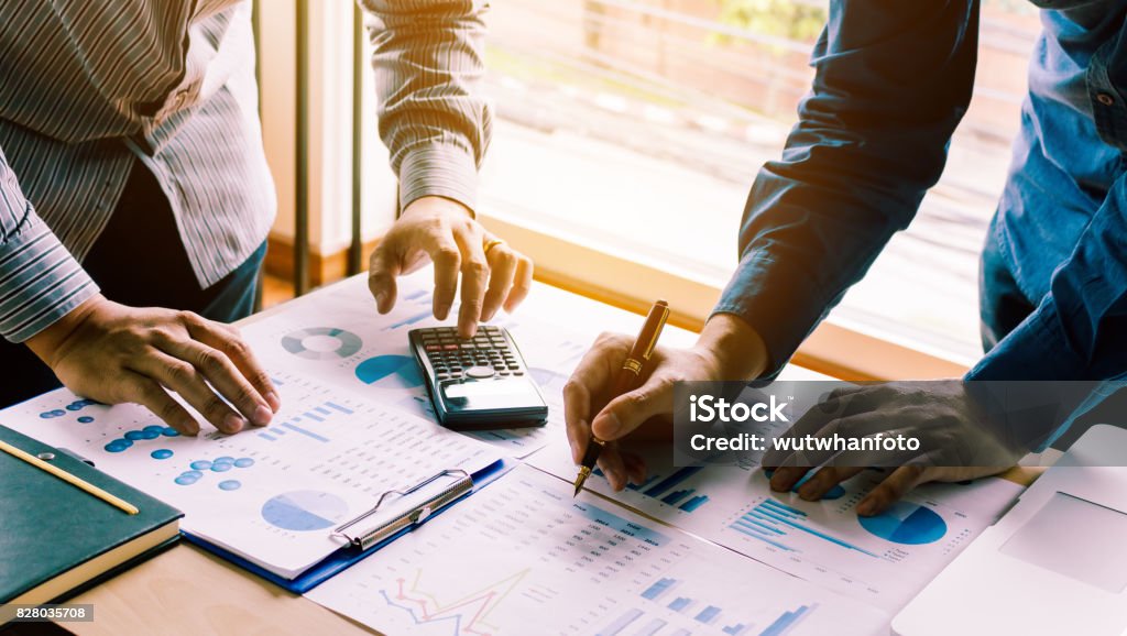 Dos equipo de empresario calcular sobre informe anual de la oficina de mesa. - Foto de stock de Negocio libre de derechos