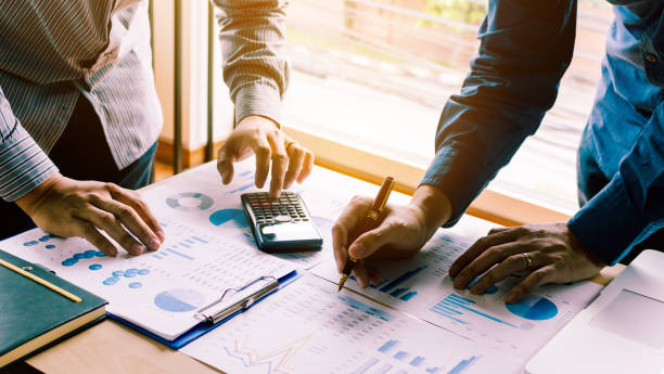 two businessman team calculate about summary report annual on table office. - flow chart strategy analyzing chart imagens e fotografias de stock