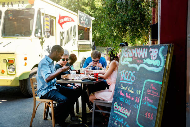 grupo de personas que comen comida de un camión de comida en un parque. - city urban scene canada commercial land vehicle fotografías e imágenes de stock