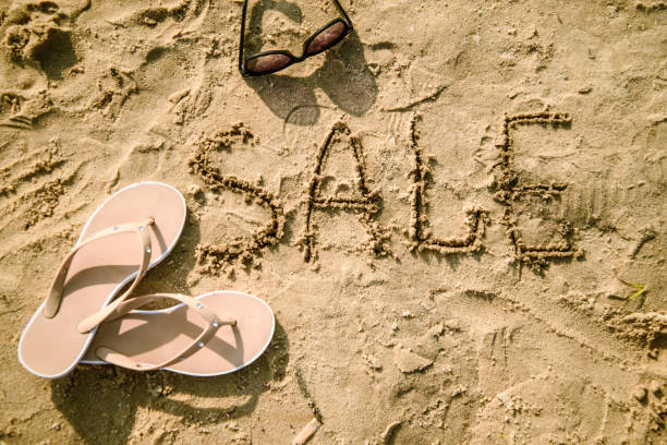 istock sale written in the sand on a beach 828048480