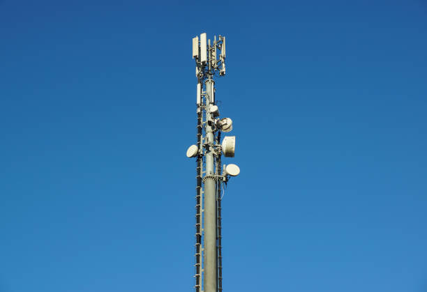 istock Top part of cell phone communication tower with multiple antennas against a blue sky 828064286