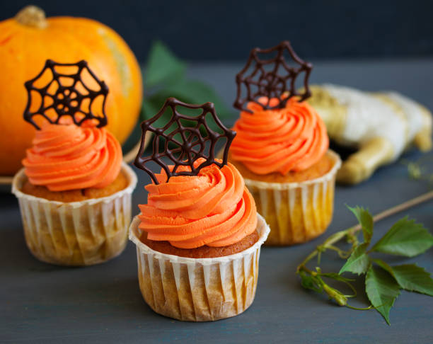 istock Pumpkin orange cupcakes for Halloween with chocolate cobweb. 828068622