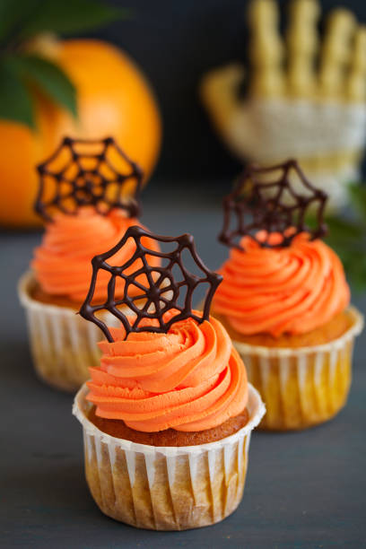 istock Pumpkin orange cupcakes for Halloween with chocolate cobweb. 828068952