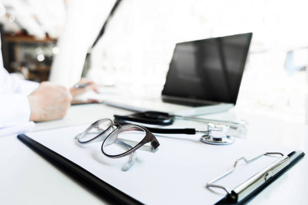 istock View of stethoscope and equipment on foreground table with doctor using computer keyboard in clinic 828073680