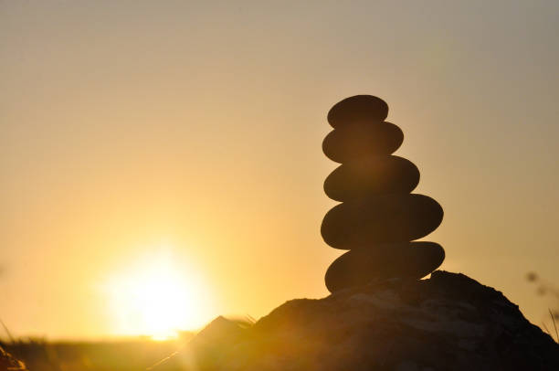 istock Silhouette of balanced stone pyramid on mountain. 828079078