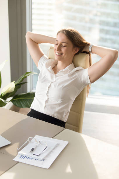 istock Smiling woman relaxing in office chair, relaxed at work, vertical 828110502