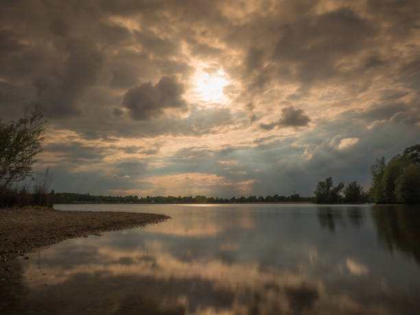 istock Long exposure at the lake with natural shore at sundown 828121608