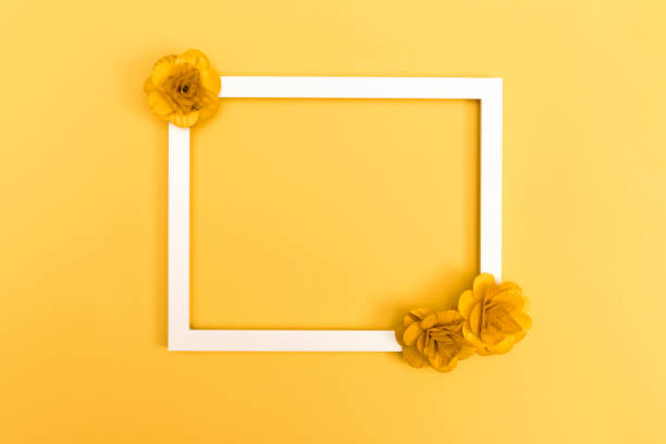 istock Picture frame with flowers on yellow 828130654