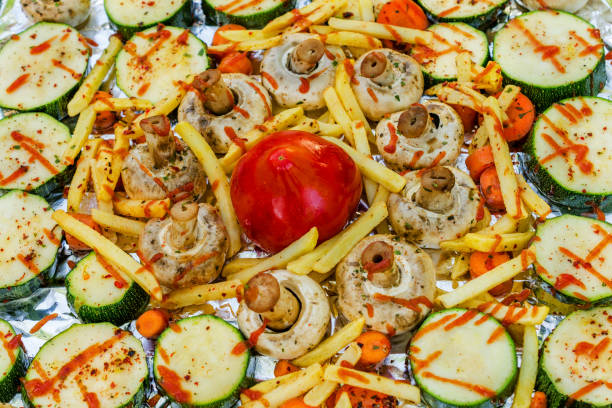 Tray of raw vegetables on the foil before cooking. Close-up.