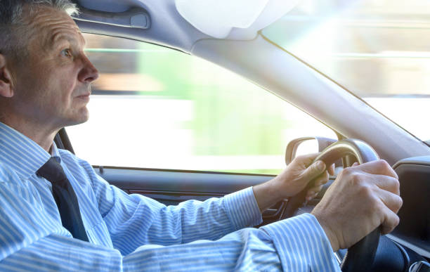 uomo d'affari alla guida di un'auto. - car driving businessman hands free device foto e immagini stock