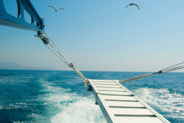 Stern of a ship sailing the sea and making waves with the blades/propellers.