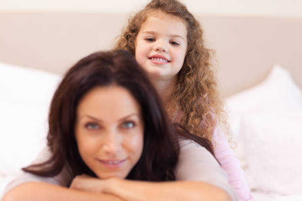 istock Smiling girl sitting on her mothers back 828167444
