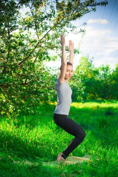 istock beautiful woman doing yoga outdoors On green grass 828180736