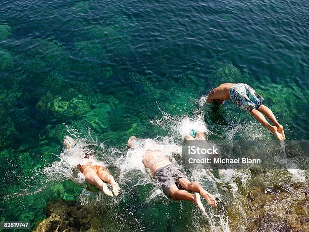 People Dive Into The Sea Stock Photo - Download Image Now - Diving Into Water, Friendship, Agility