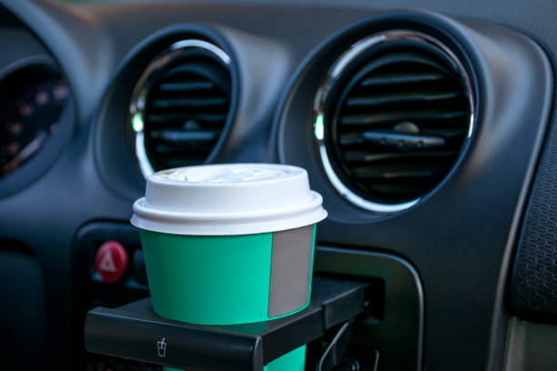 車のカップ ホルダーの中の紙のコーヒー カップ