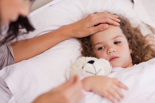 Young mother taking care of her ill daughter