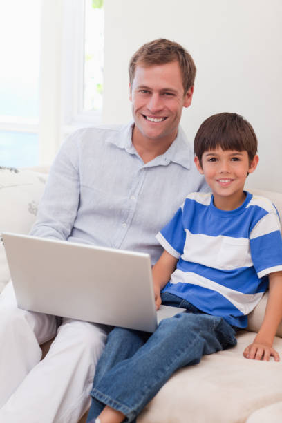 istock Smiling father and son surfing the internet together 828209454